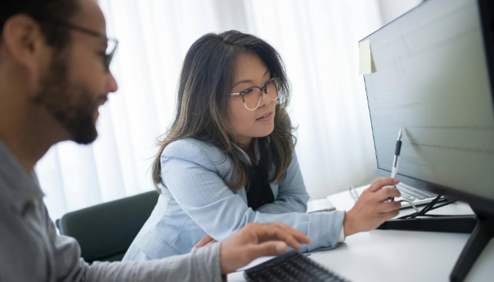 woman and man looking at computer screen talking