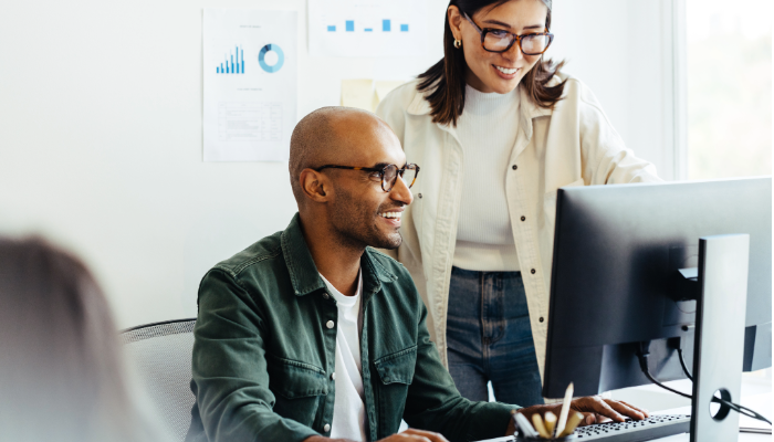 woman and man looking at computer screen talking