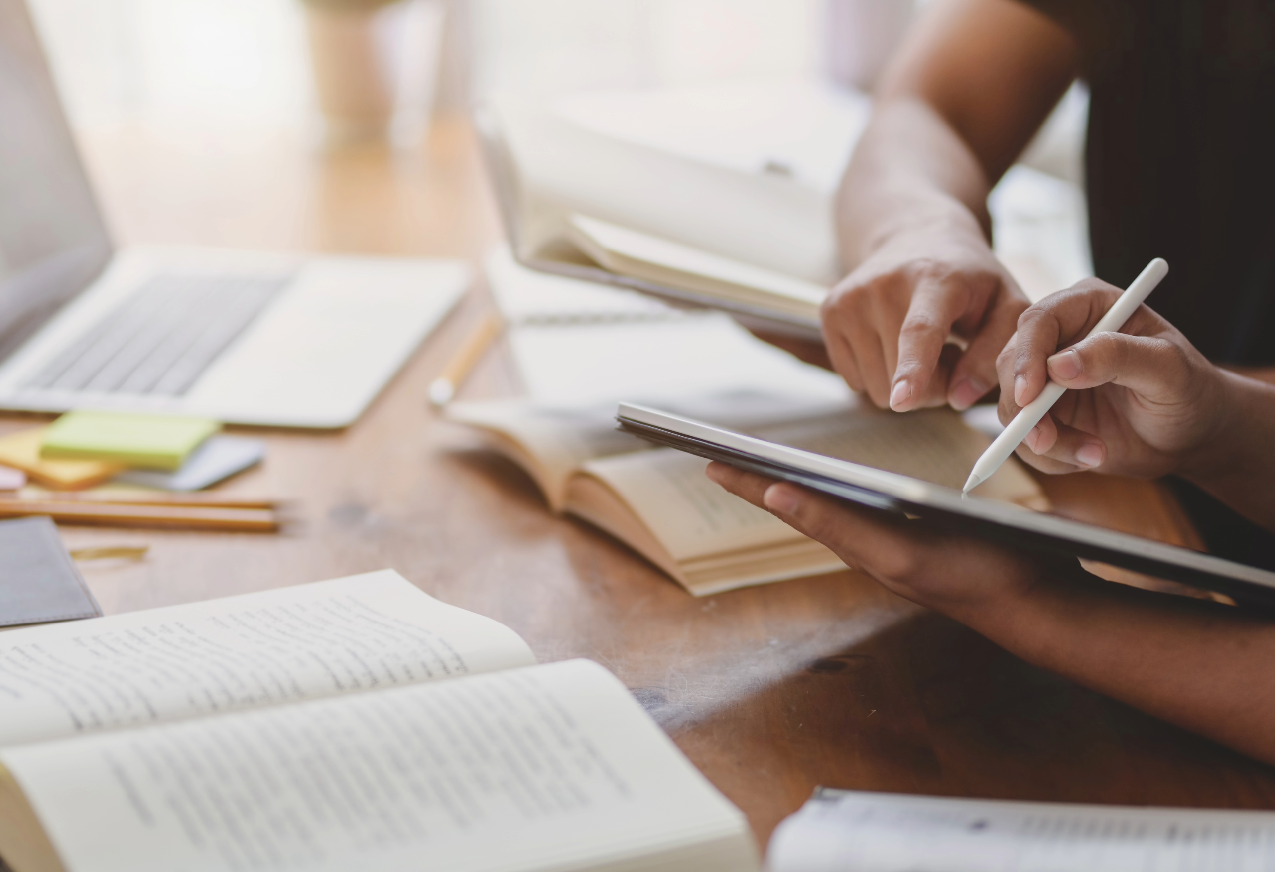 books open on the table, people using a tablet