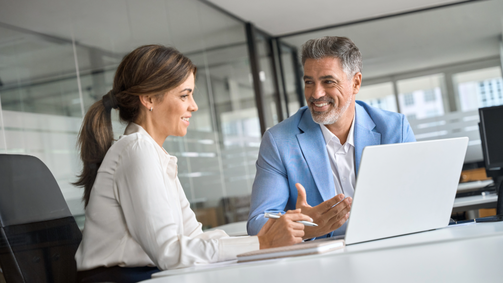 woman and man discussing in front of a laptop